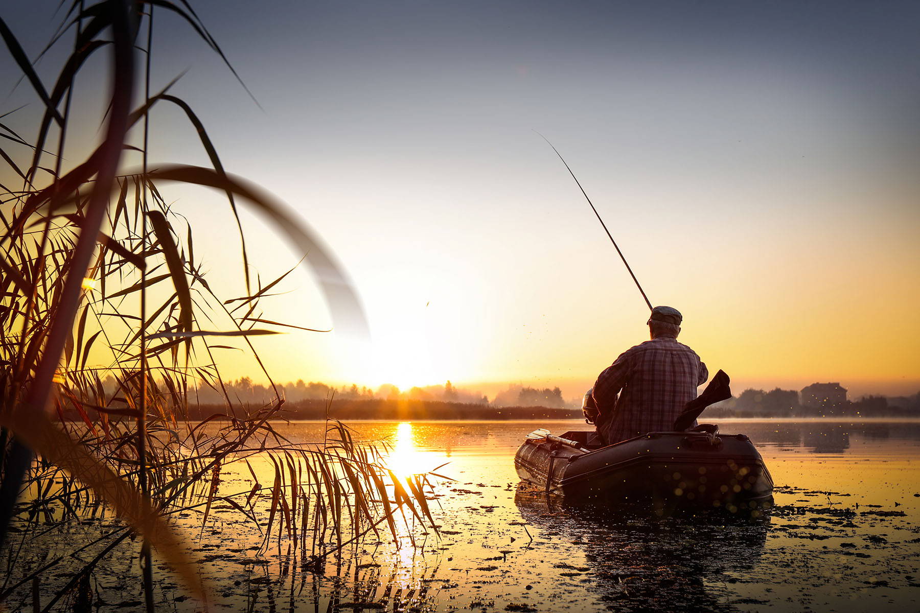 Man Fishing in Boat at Dawn