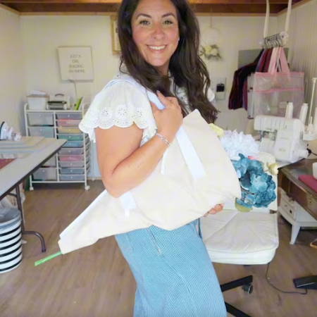 Women holding a handmade fresh cut flower tote bag filled with fresh flowers, sewn from canvas fabric with cotton handles