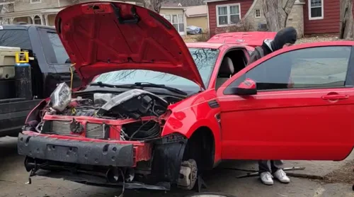 Red Ford Focus with hood open during train horn install