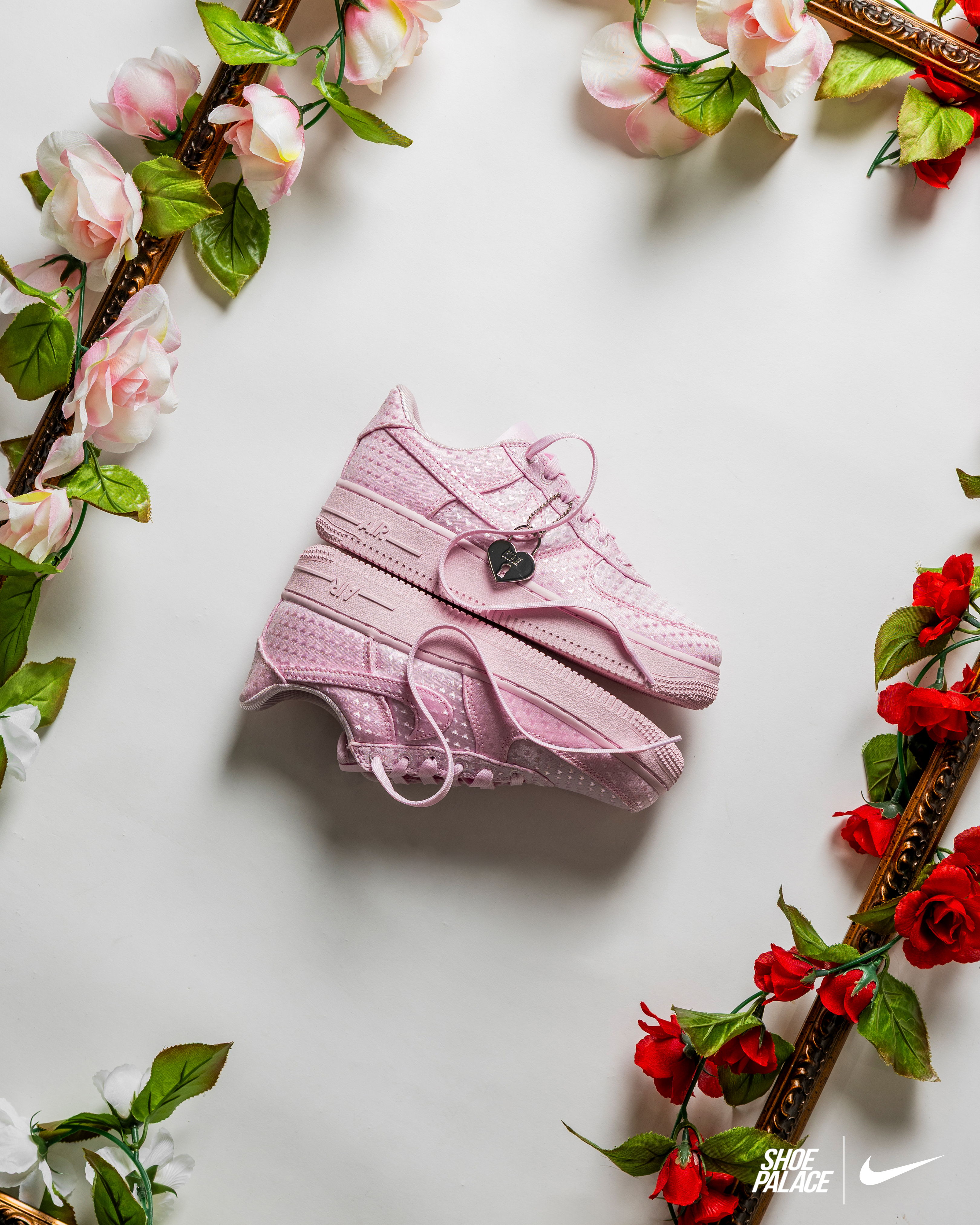 Pink sneakers surrounded by floral decorations on a light background.