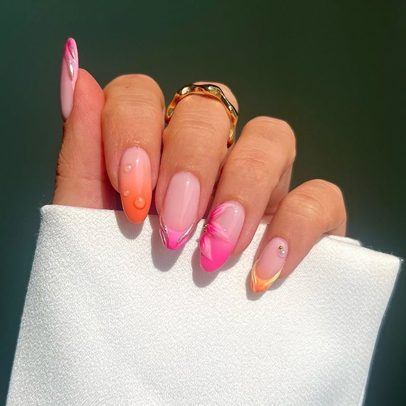 A hand with colorful nail art holding a white cloth.