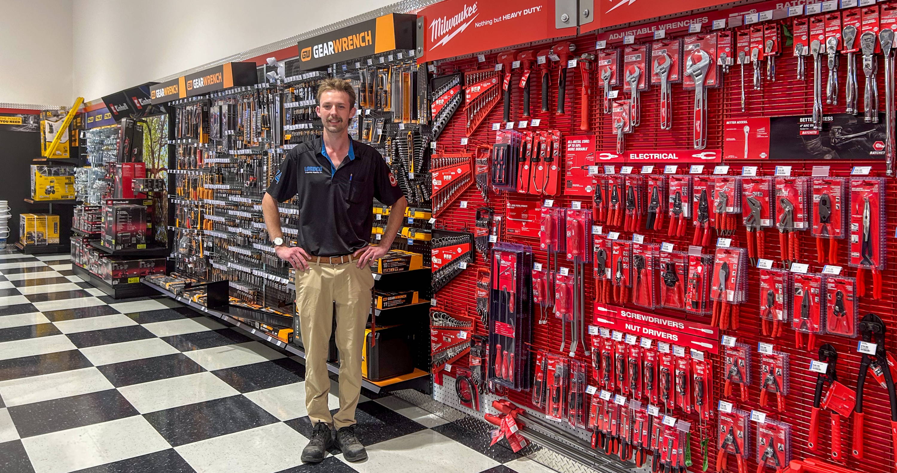Person standing in a hardware store aisle filled with tools.