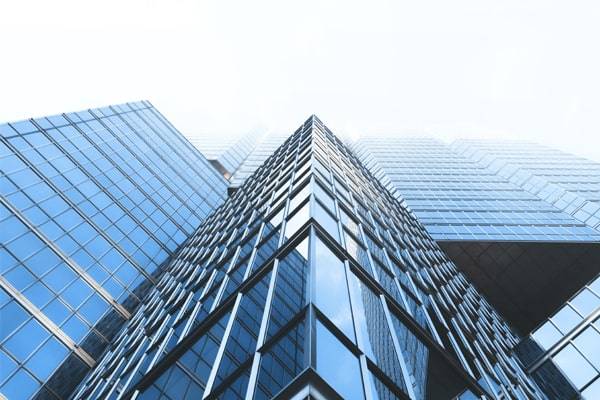 Modern Blue & Black glass skyscrapers framed from below.