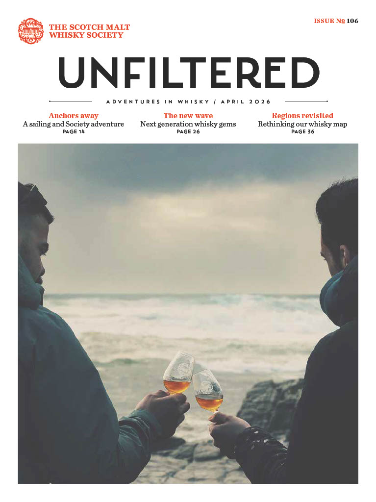 Two people toasting with glasses near the sea on a magazine cover.