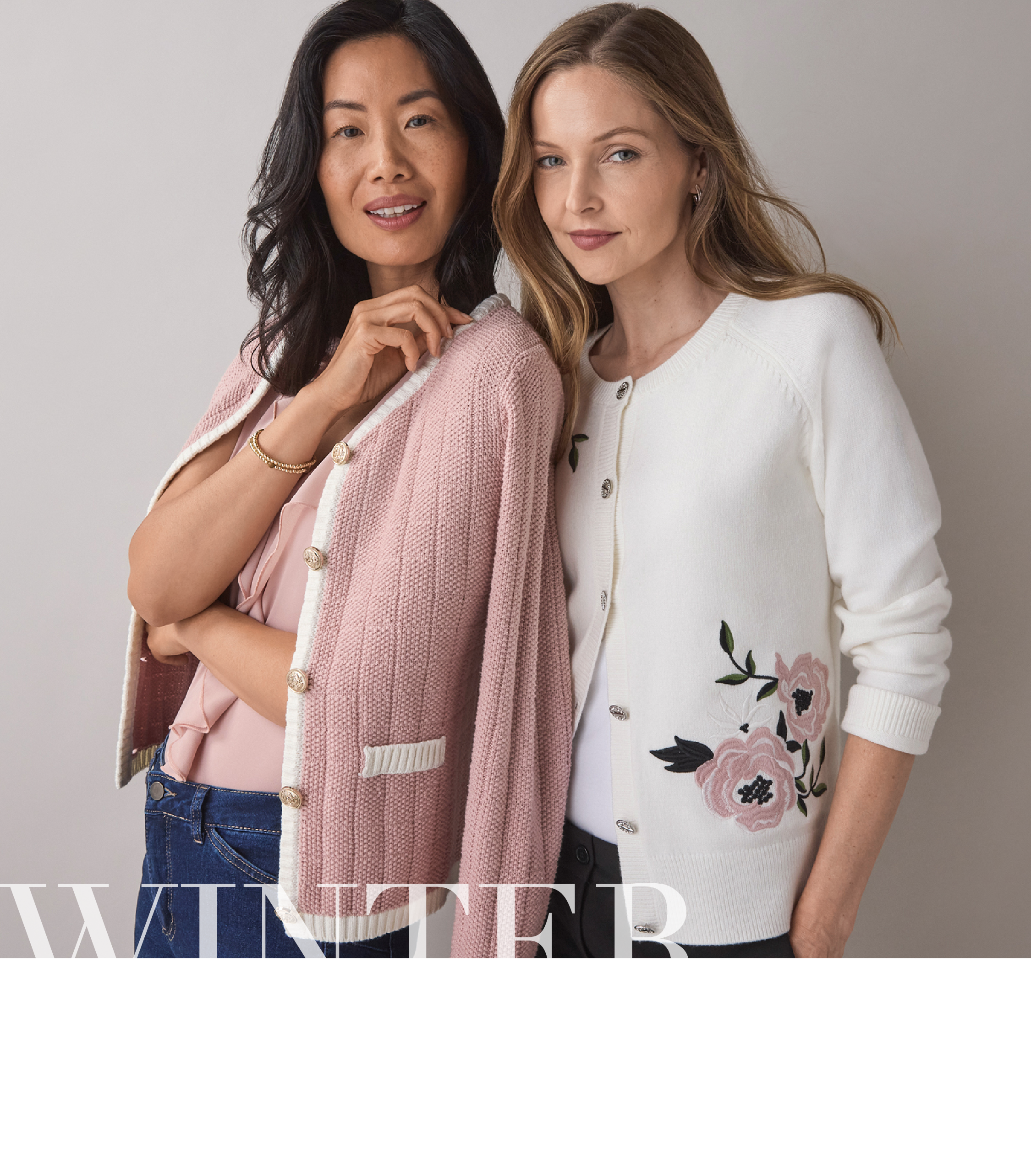 Two women modeling winter fashion with floral and textured cardigans.