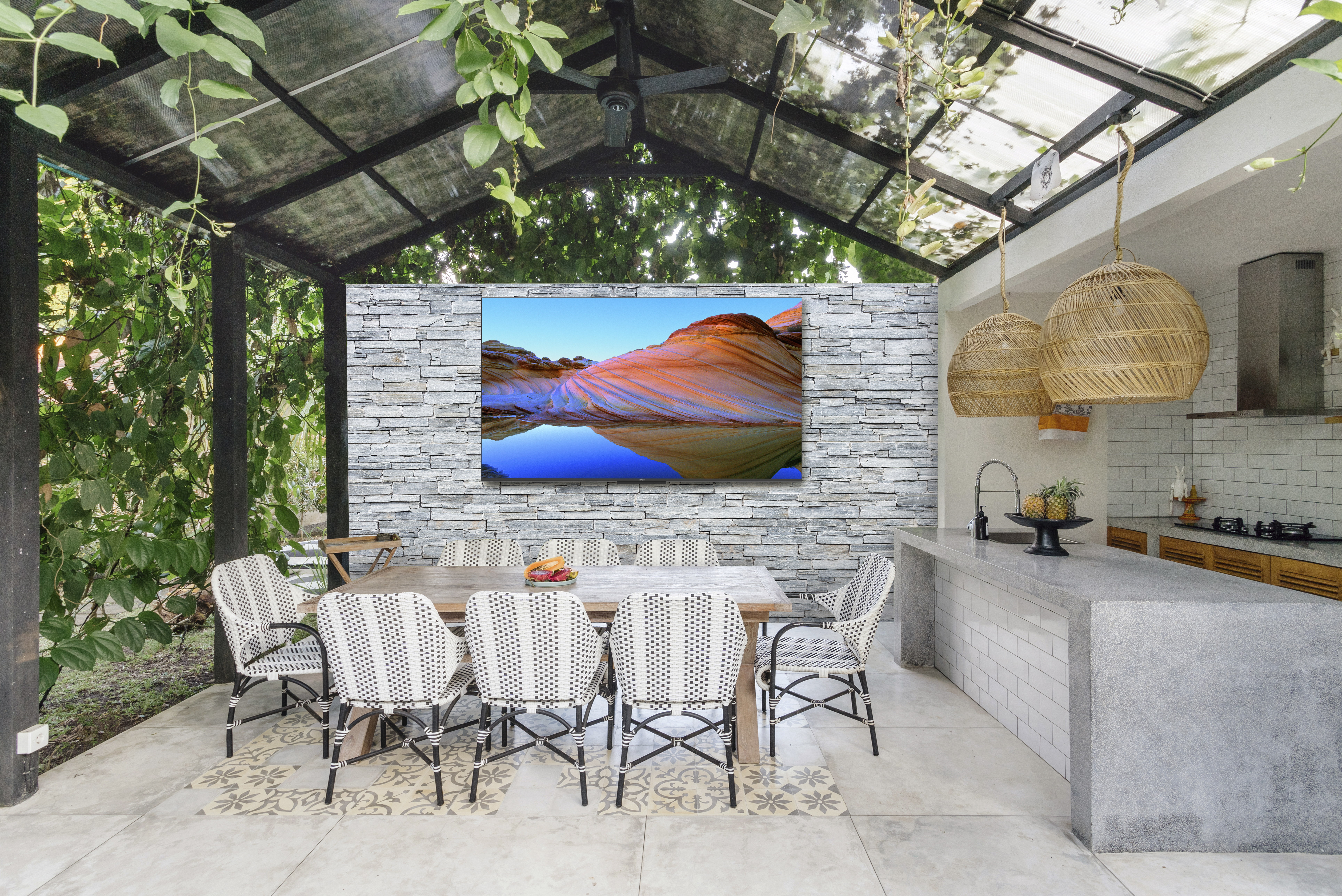 Outdoor dining area with a TV and modern decor.