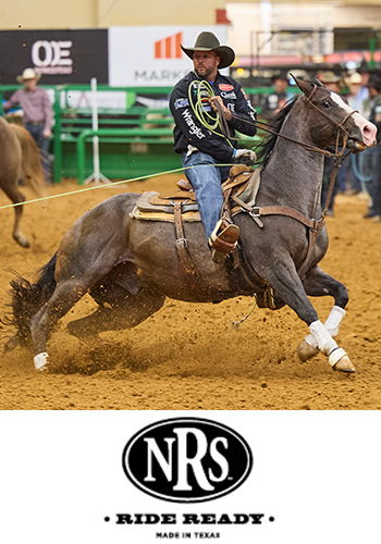 Cowboy riding a horse while roping in a rodeo arena.