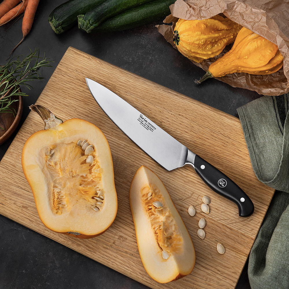20cm Professional Chef's Knife on a cutting board with sliced squash and vegetables in the background.