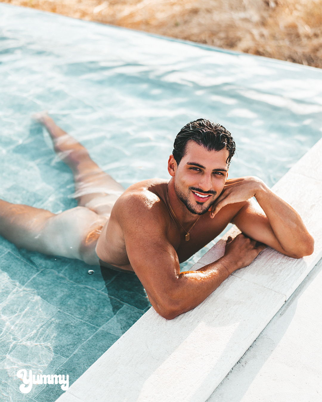 Man relaxing in a pool, smiling, with water around him.