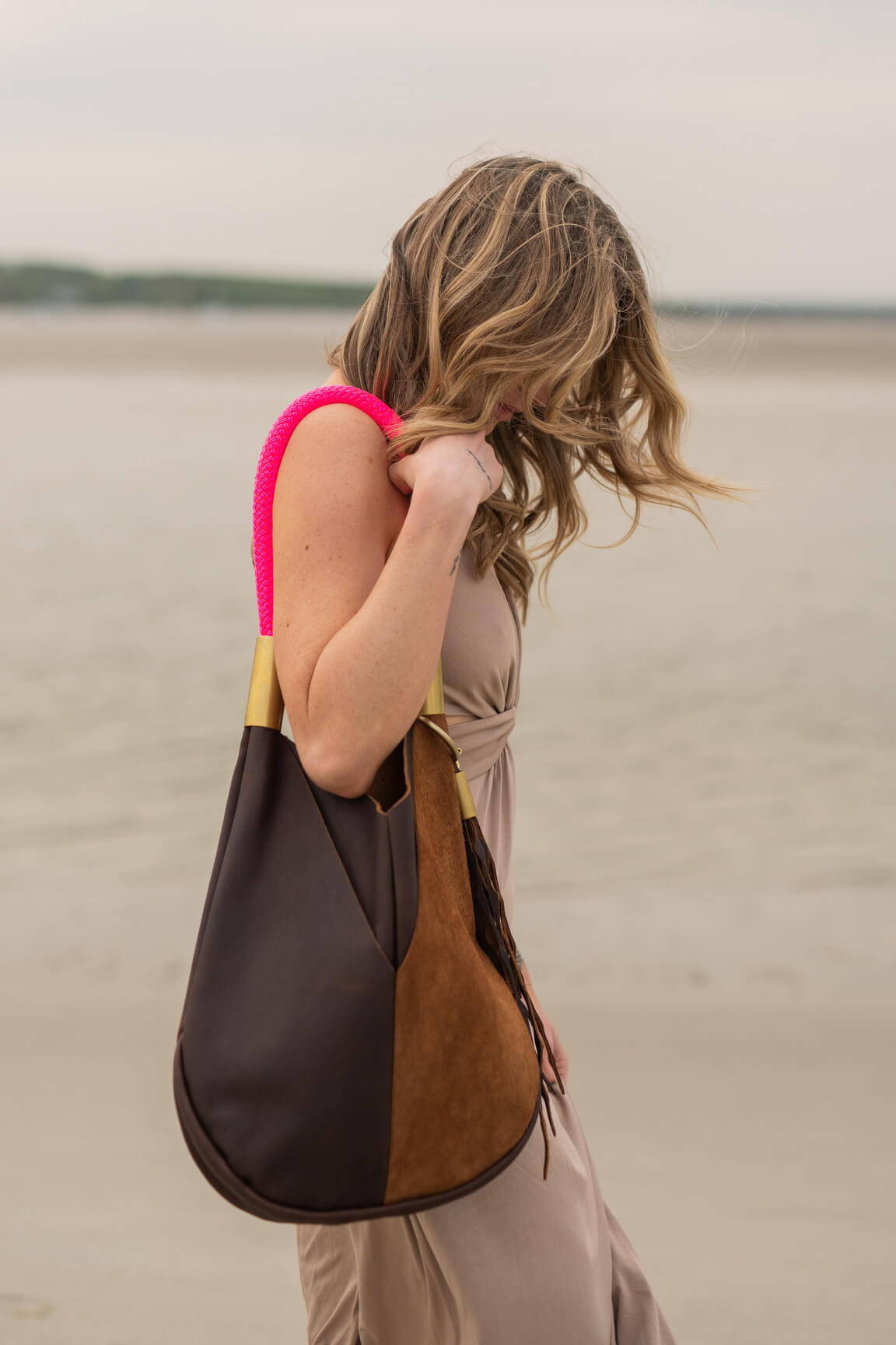 woman wearing brown leather tote with neon pink dock line