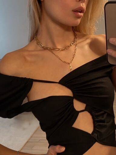 A selfie of Frida Aasen wearing a black top and two golden necklaces.