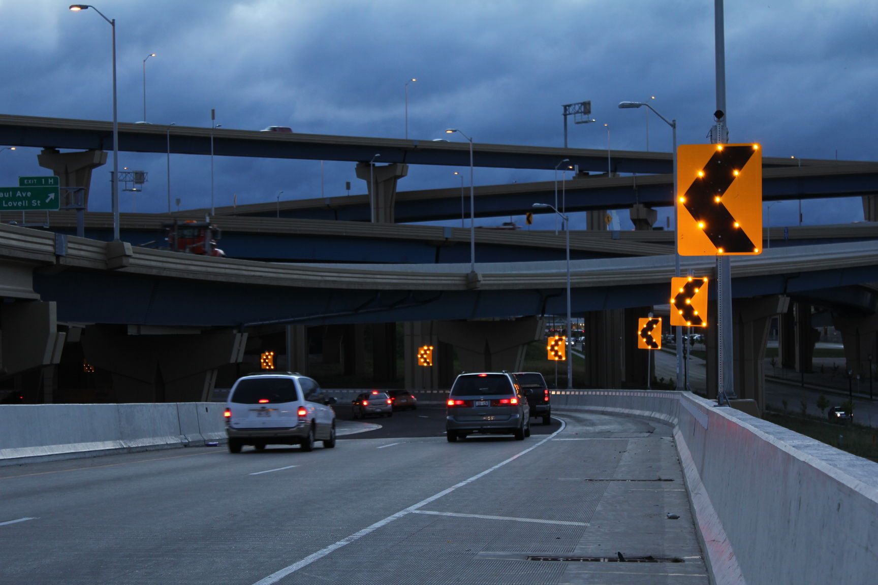 Sequential LED chevrons flashing along a highway curve