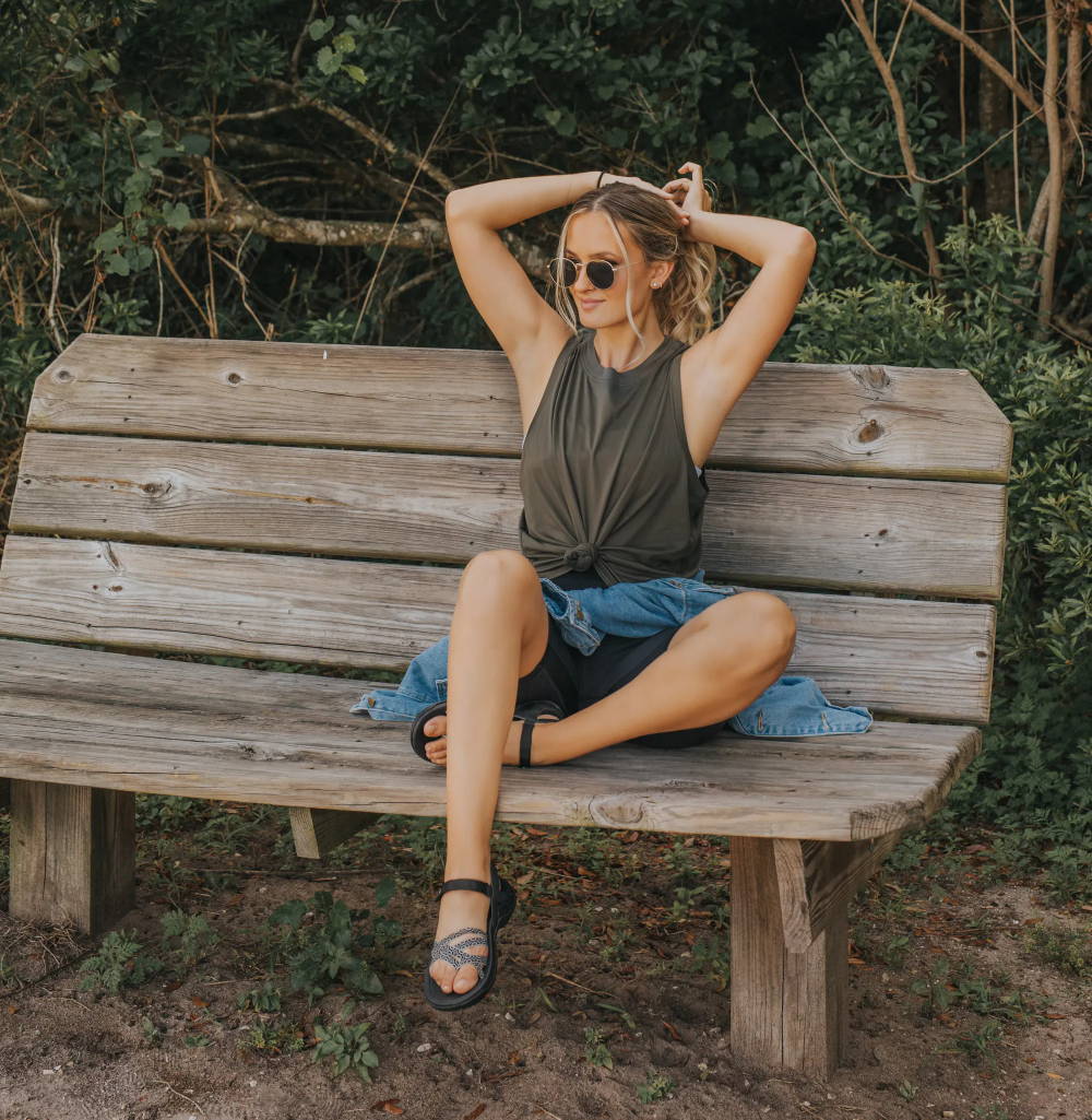 woman sitting on bench in walking sandals with arch support