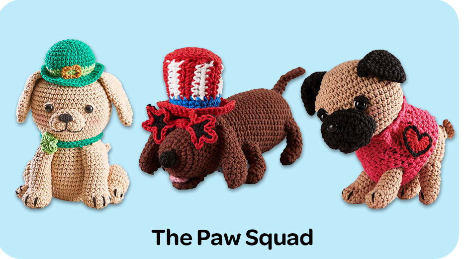 Three amigurumi dogs in various outfits against a blue background. Paw Squad
