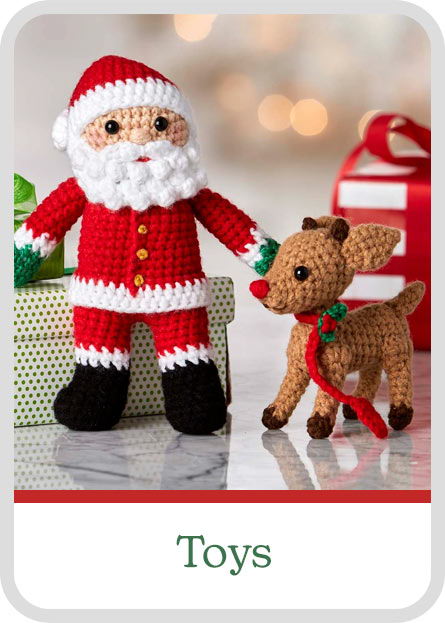 Crocheted Santa and reindeer with holiday gifts in the background. Labeled 