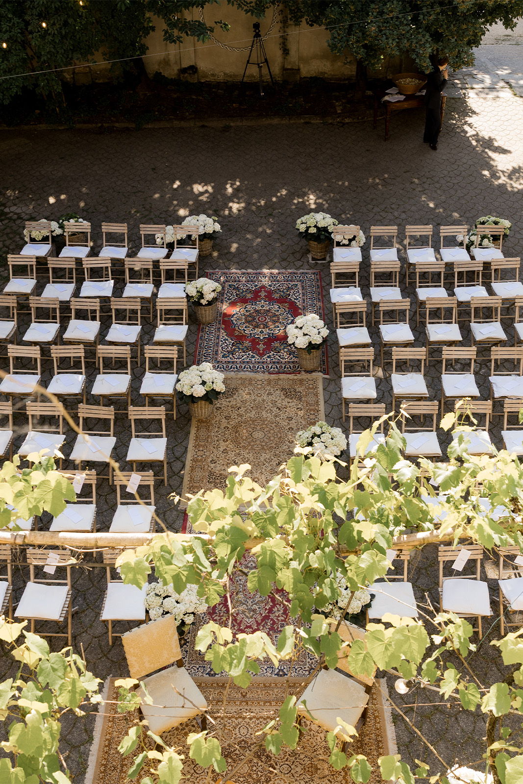 Outdoor wedding setup with chairs, floral arrangements, and a decorative aisle.