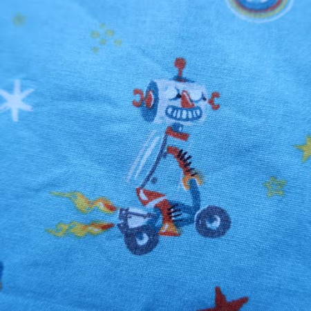 detail of blue cotton fabric with little robot designs