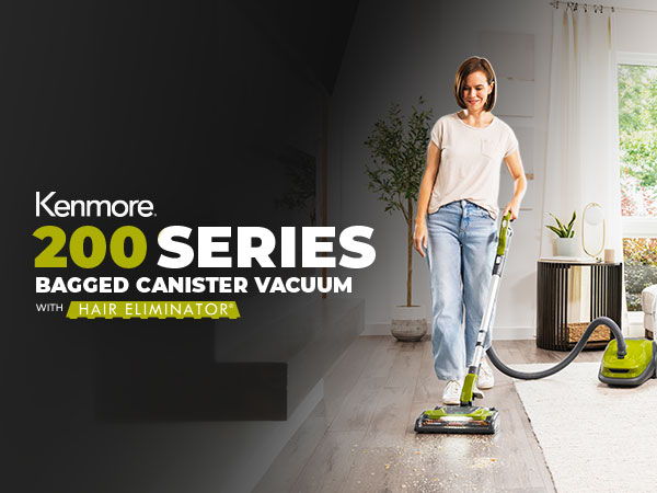 Woman using Kenmore 200 Series bagged canister vacuum in a modern living room.