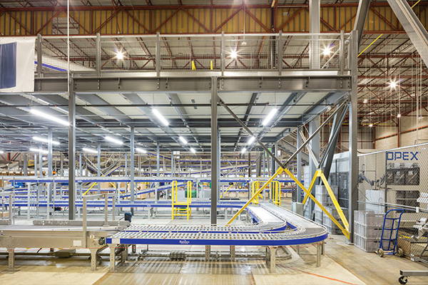 Mezzanine installed over assembly line, used for extra storage.