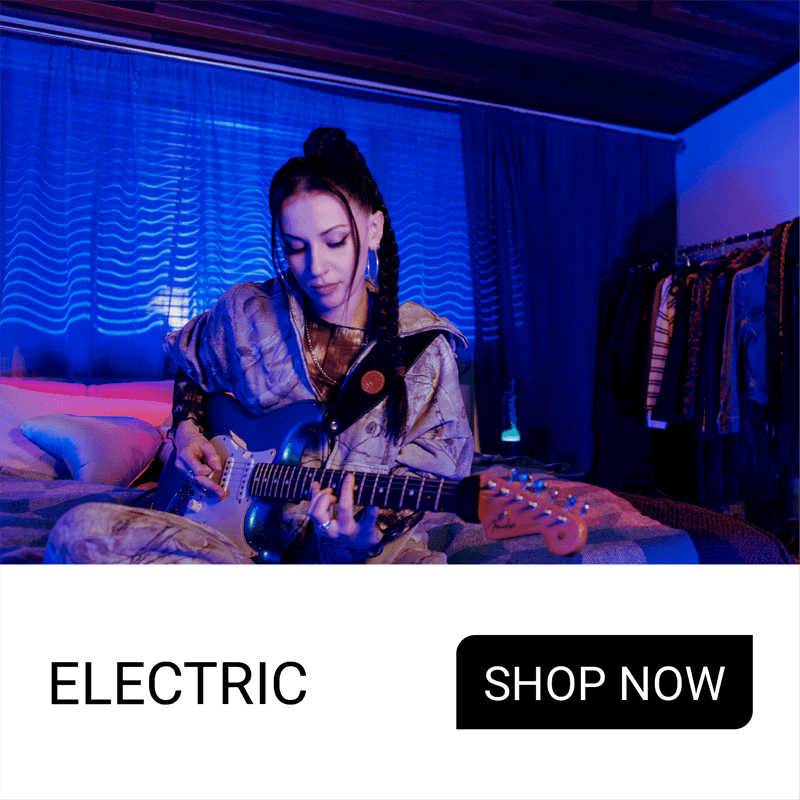 Person playing guitar in a dimly lit room with blue lighting.