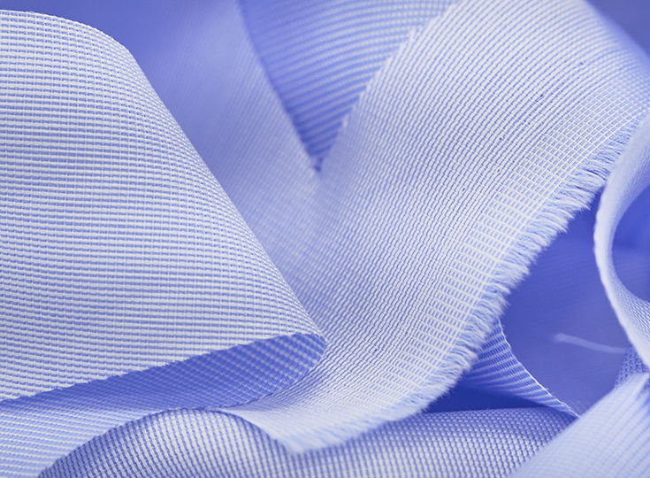 Close-up of light blue fabric with textured folds and drapes.