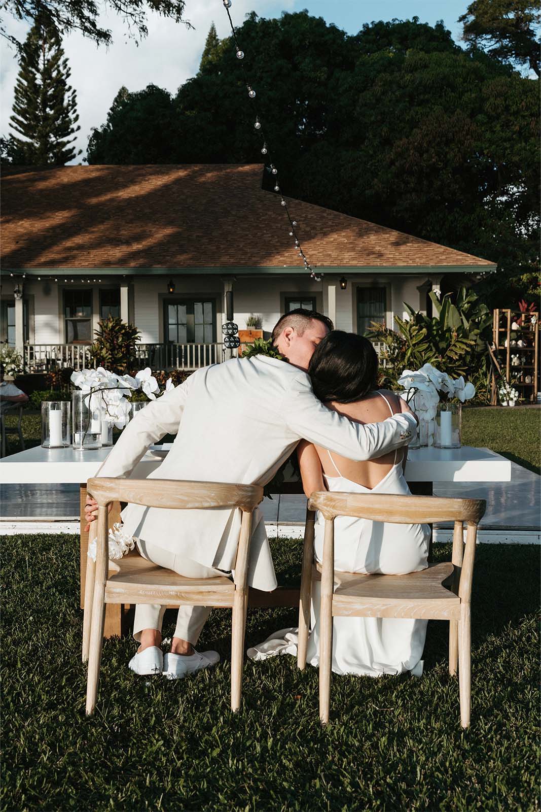 Bride and groom sharing a kiss at wedding table