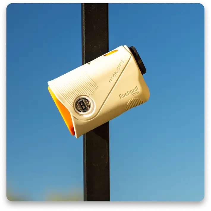 A white and orange camera mounted on a pole against a blue sky.