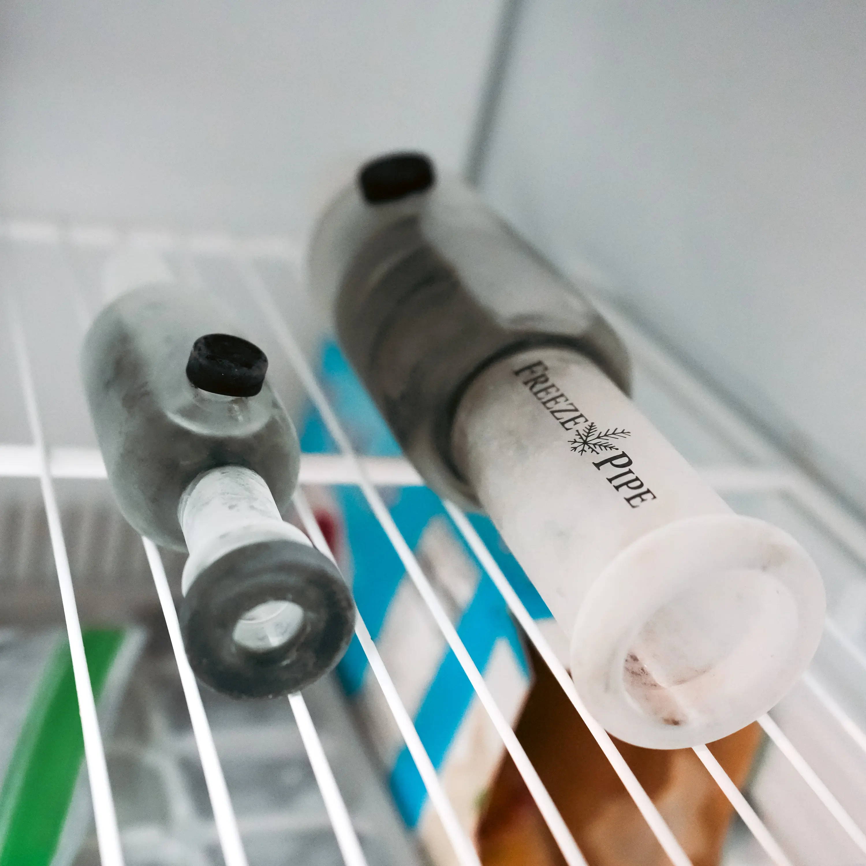 Glass spoon pipes’ detachable glycerin chambers on a freezer shelf