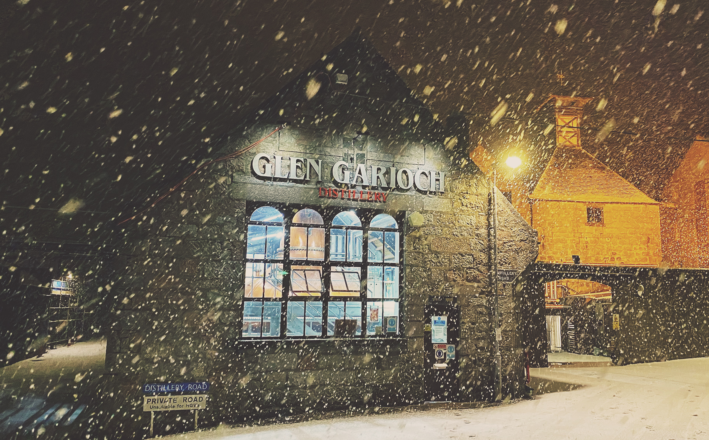Snowy night scene of a building with illuminated windows.