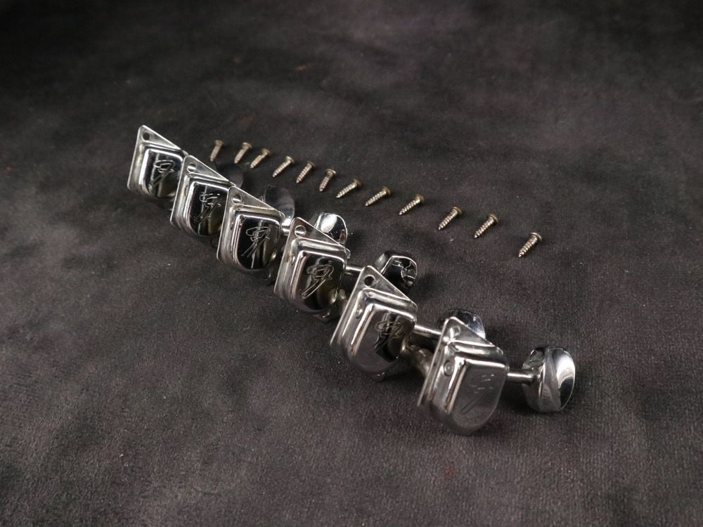 Metal mechanical components and screws arranged on a dark surface.