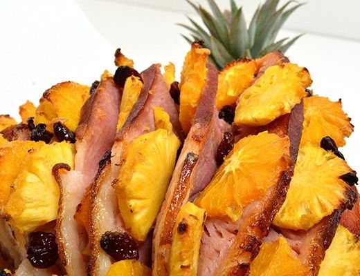 A ham dish garnished with pineapple slices.