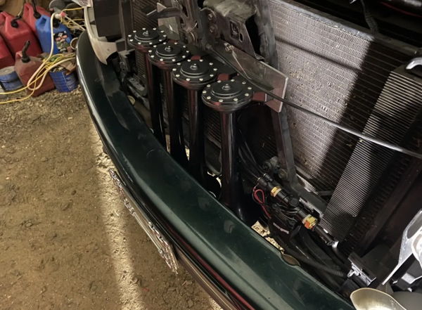 Close-up angle of the Shocker S4 horn mounting behind the front bumper on Dalton's 2001 Chevy Tahoe, install photo 4