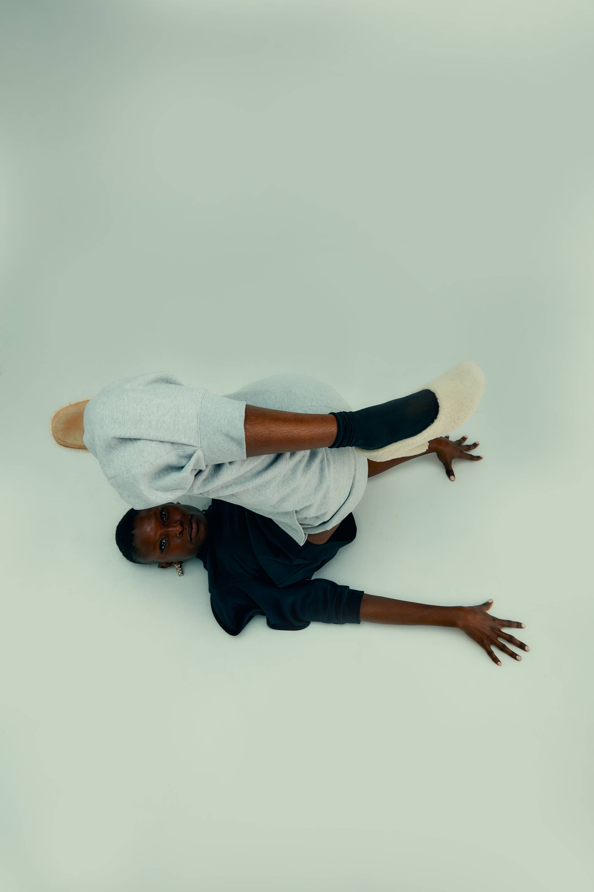 A person performing an acrobatic pose on a light background.