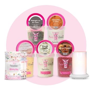Assorted bath products and a candle on a pink background.