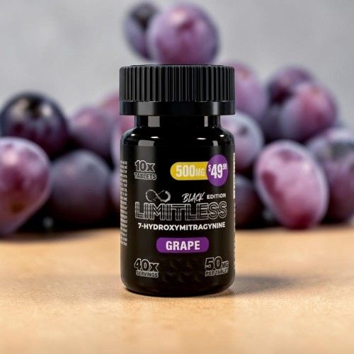 Bottle of grape-flavored supplement with grapes in the background.