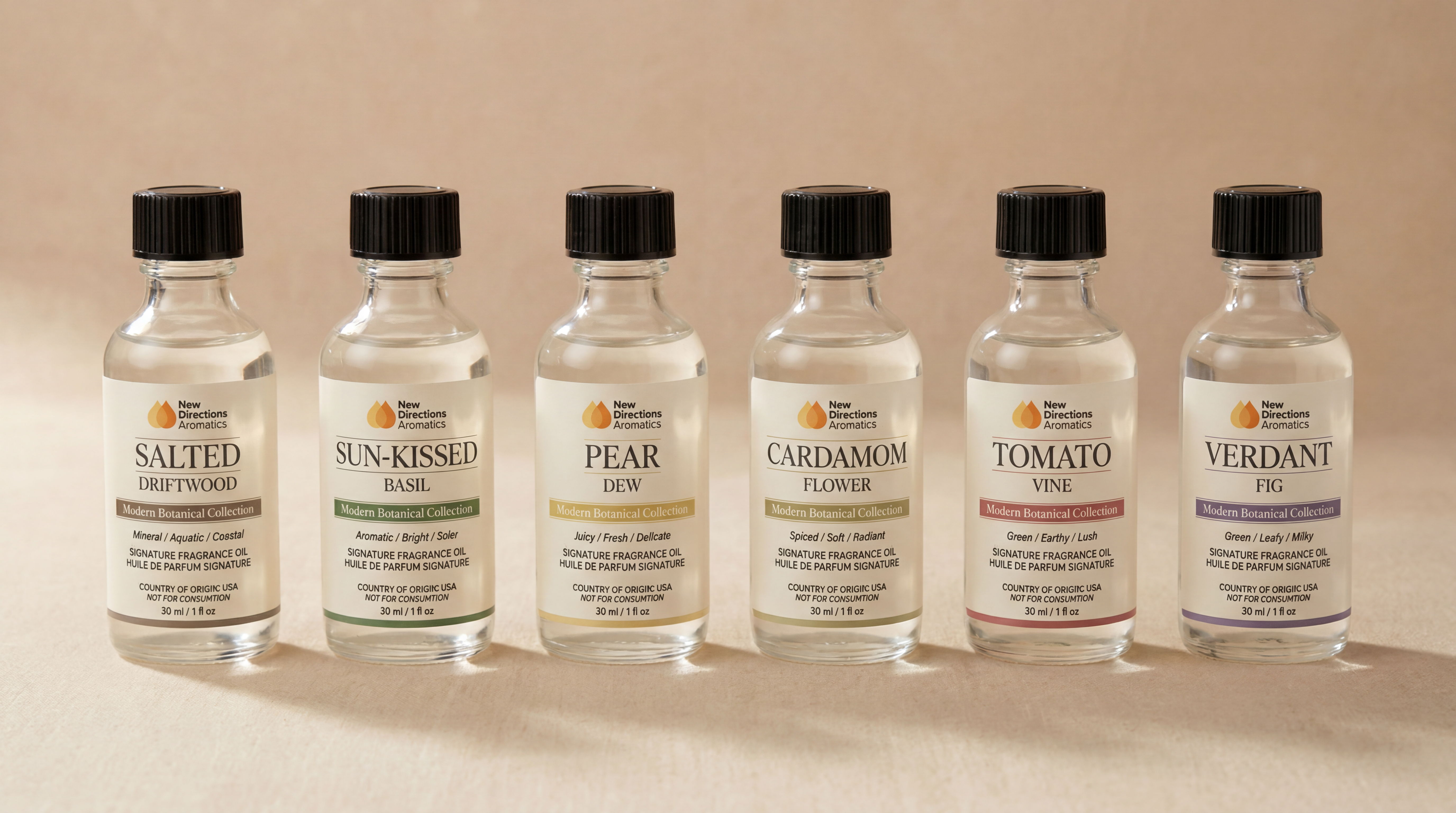 Six bottles of various liquids with black caps on a light background.