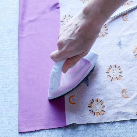ironing the newly sewn seam of the pillowcase
