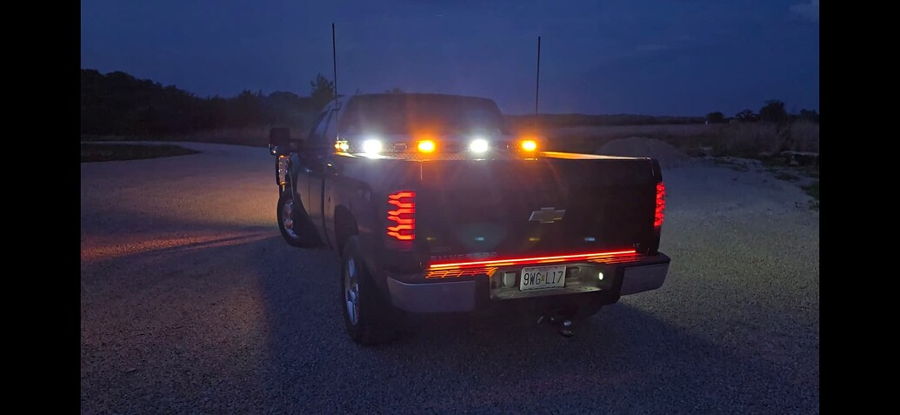 Rear three-quarter view Hunter's 2012 Chevy Silverado at night with LED tail lights red light bar and amber white bed auxiliary lights gallery photo 3