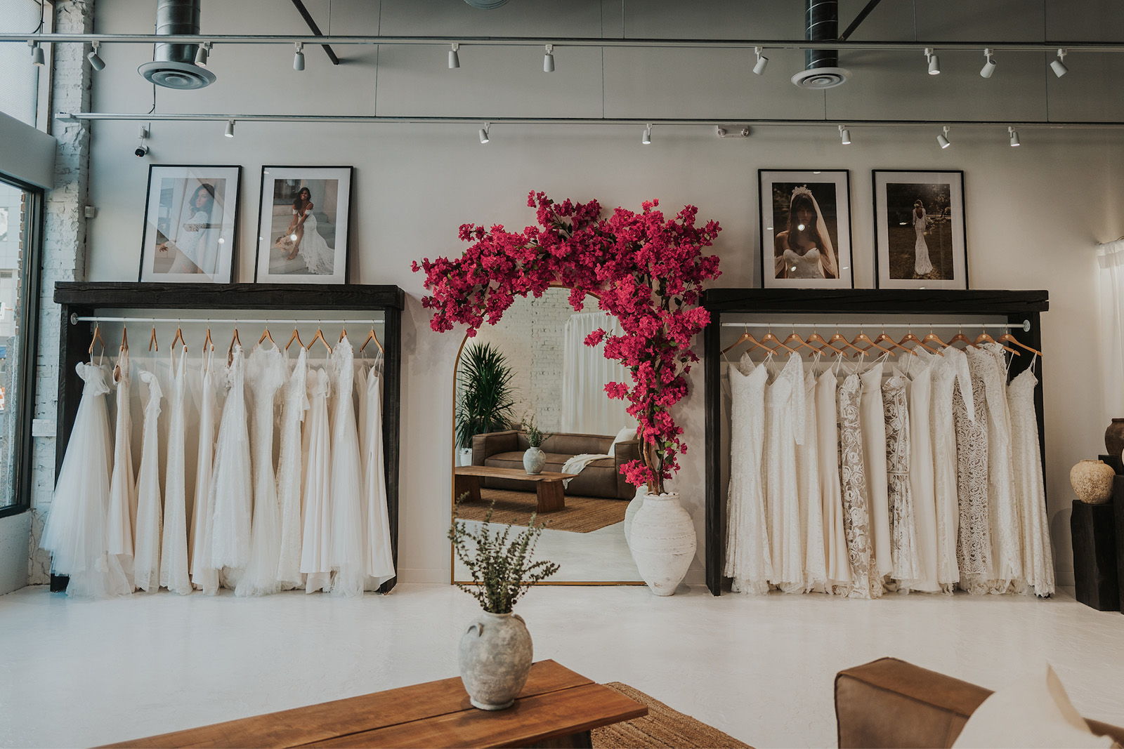 A stylish interior with white curtains, floral decor, and framed art.