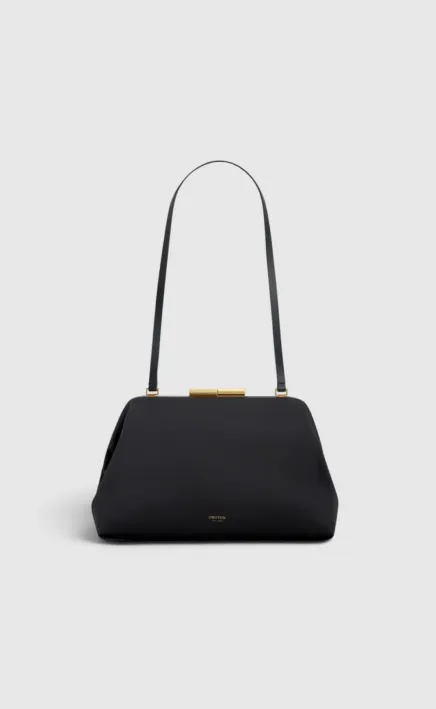 Black handbag with a long strap and gold clasp.