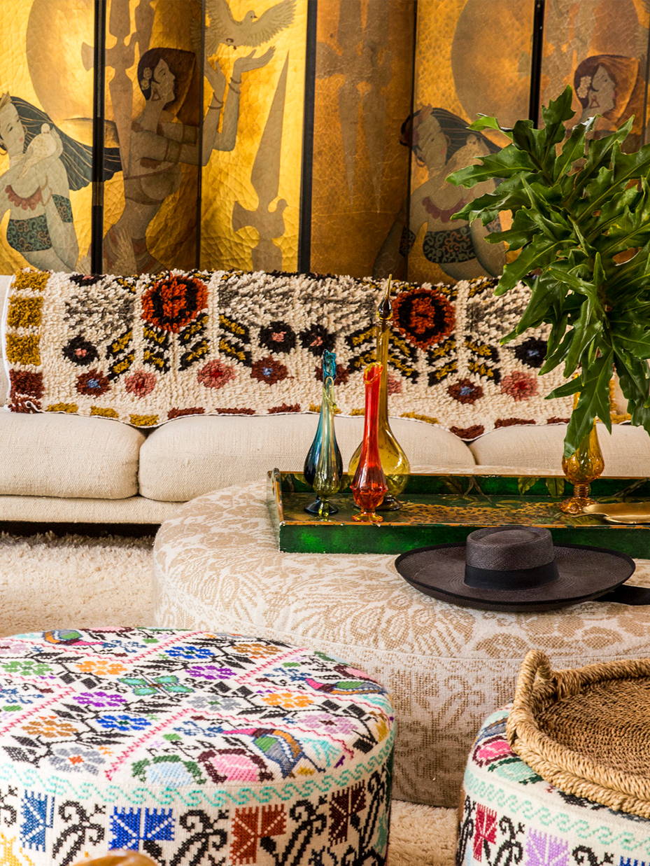 A couch and ottoman with different handmade textiles 