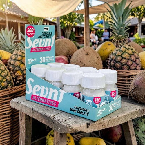 Bottles of Sevn supplements displayed at a fruit market.
