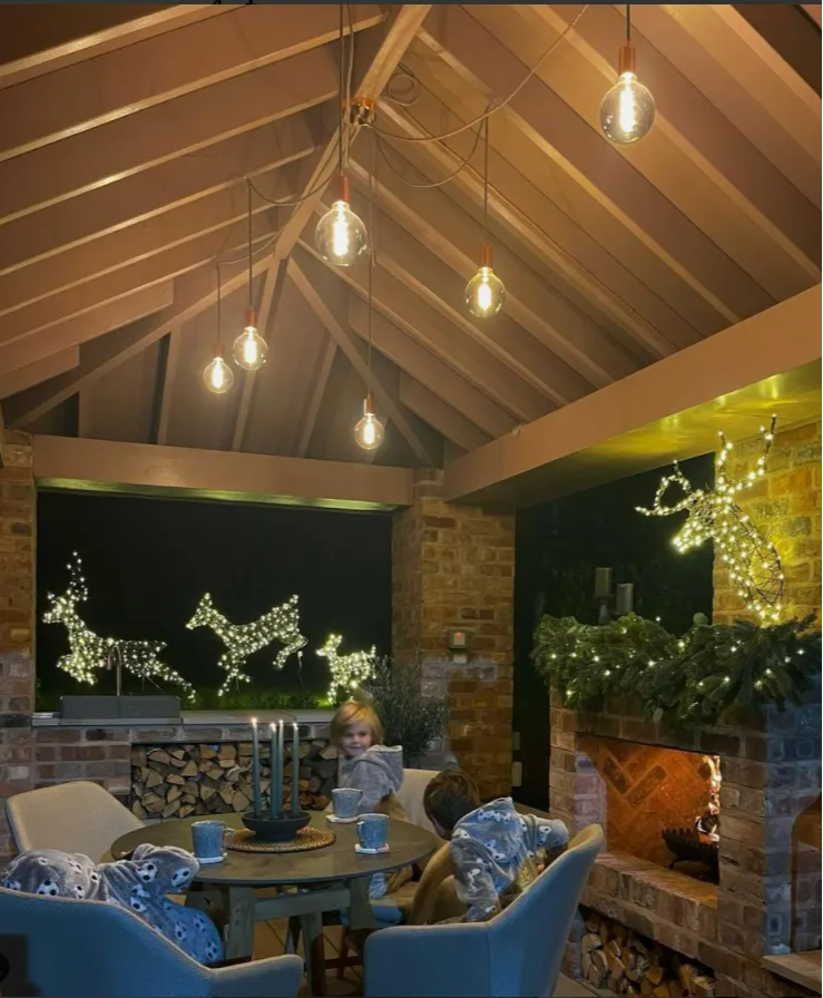 An outdoor dining setting with reindeer family and Stag head with a cosy fire. 