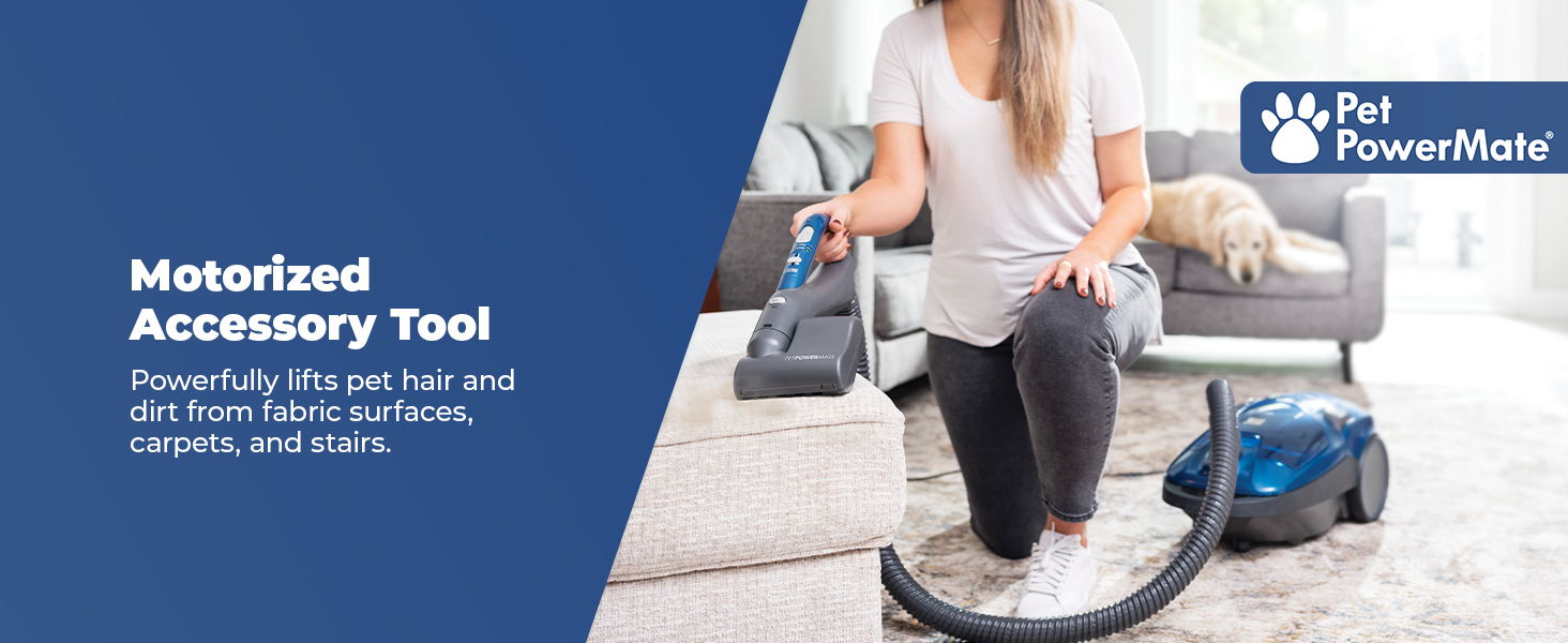 Person using a motorized vacuum accessory tool on a carpet.