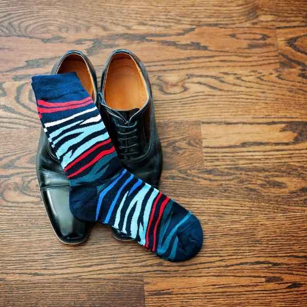 Colorful zebra socks on top of black dress shoes