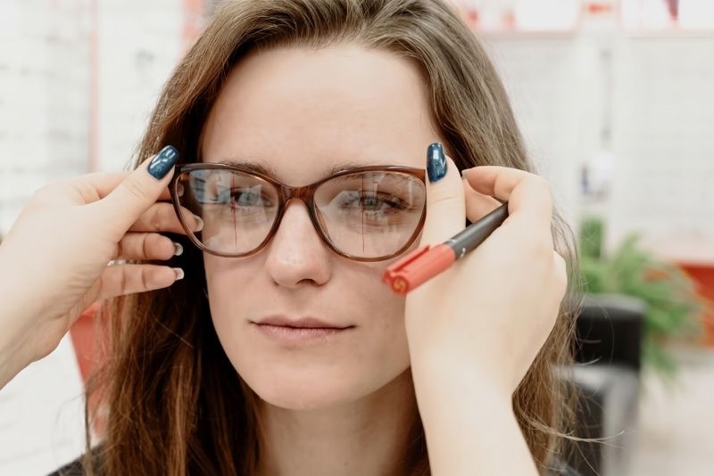 Optician adjusting progressive glasses on woman