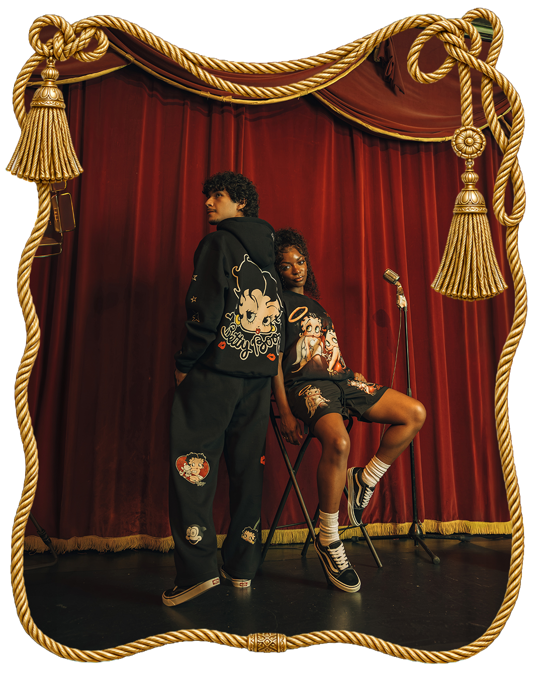Two models pose in stylish outfits on stage.