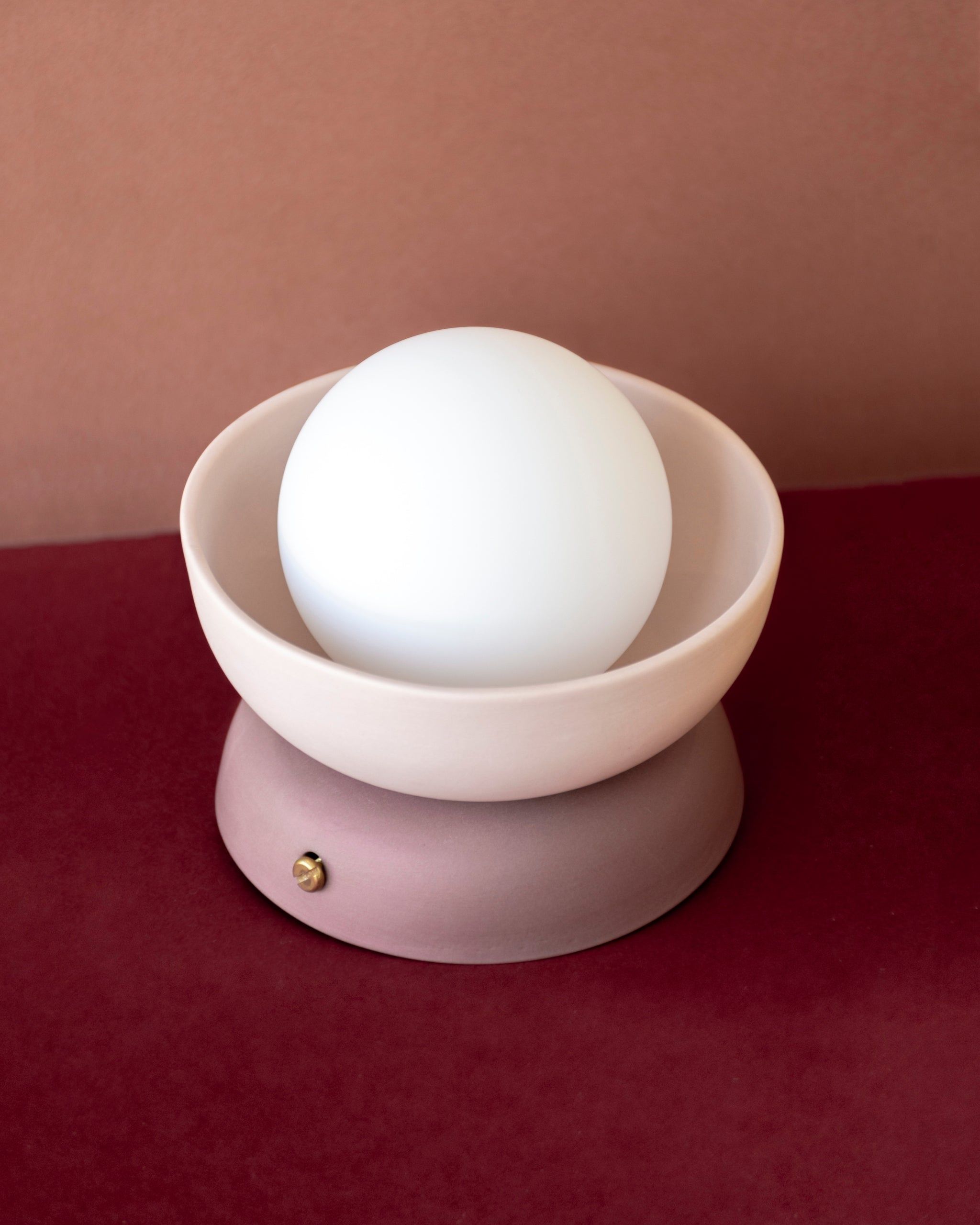 Ceramic Mani Mini light fixture with a cream and pink finish on a magenta background