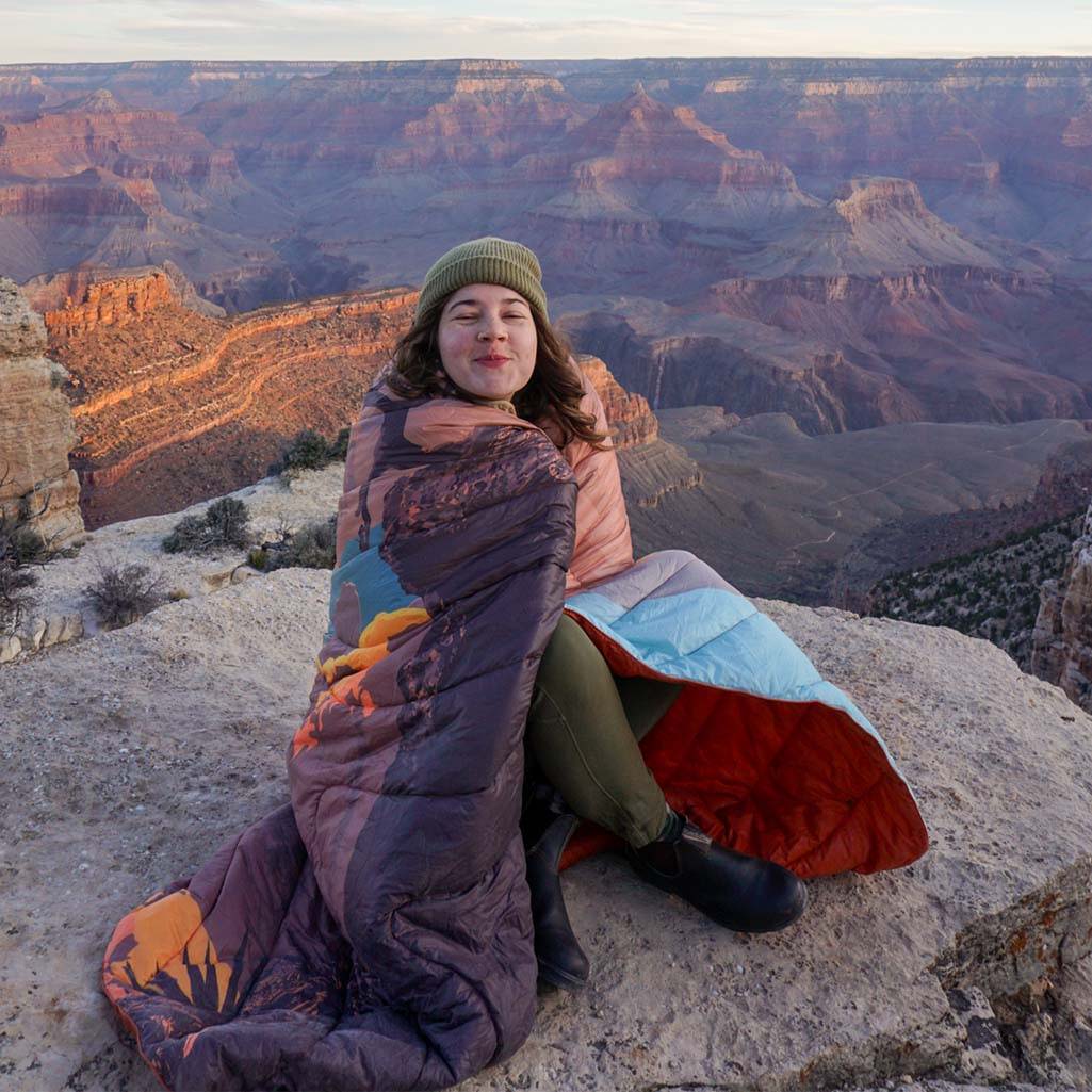 Woman Wrapped In Rumpl Grand Canyon Blanket On Side Of Grand Canyon