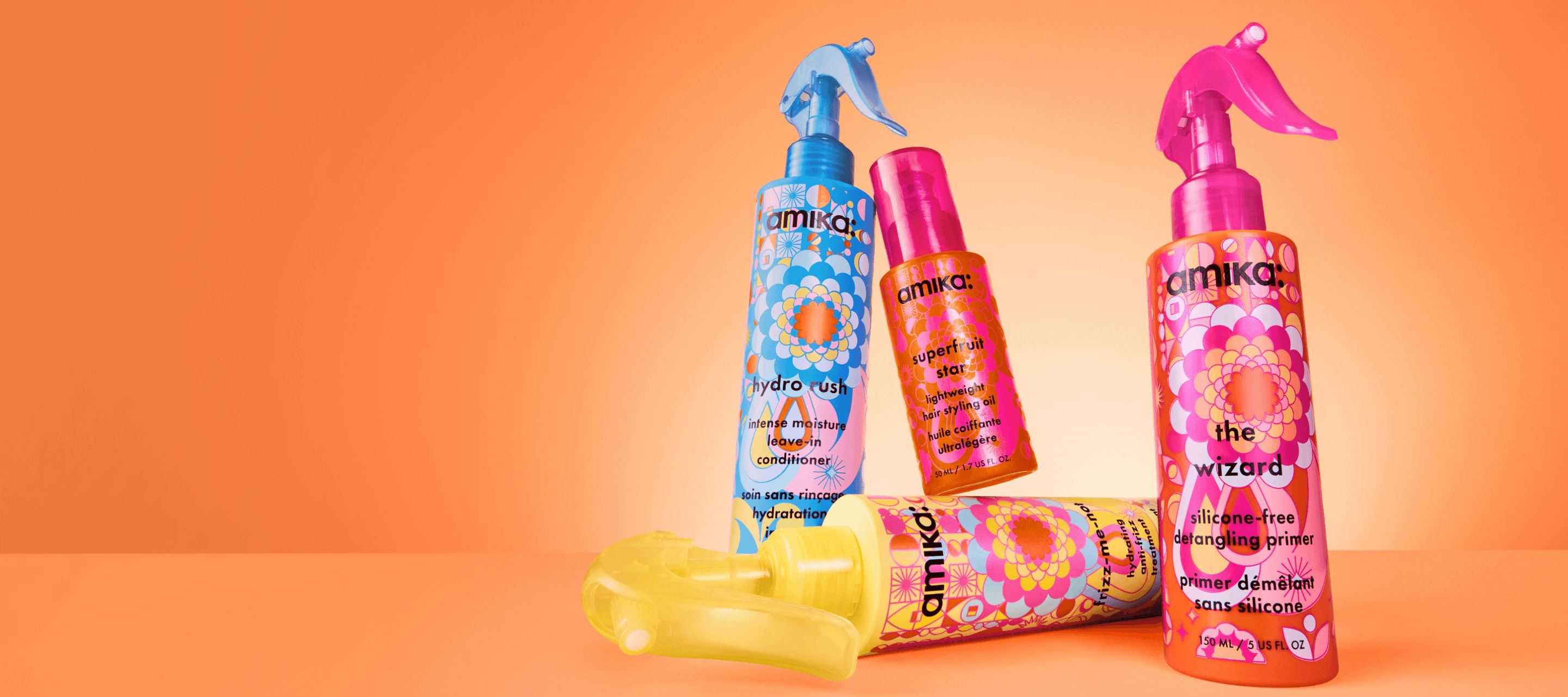 Four colorful hair products on an orange background.